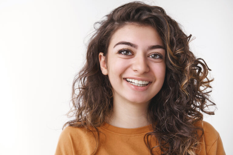 Young woman with a natural bright smile after dental facial rejuvenation treatment at White Diamond Dental in Colorado Springs