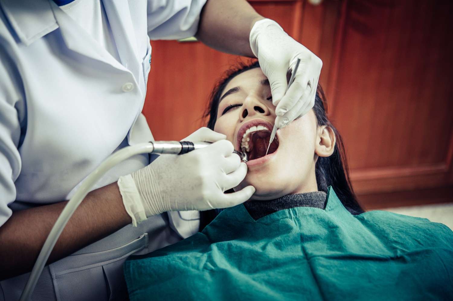 Dentist performing emergency dental procedure to treat tooth pain and infection at White Diamond Dental